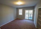 Thumbnail 7 of 14 - an empty living room with a door to a patio