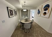 Thumbnail 30 of 48 - A dining room with a table and chairs.