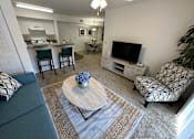Thumbnail 31 of 48 - A living room with a grey couch and a coffee table.