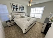 Thumbnail 32 of 48 - A bedroom with a bed, nightstand, and two framed artworks on the wall.
