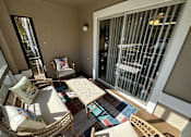 Thumbnail 35 of 48 - A sunny balcony with a table and chairs.