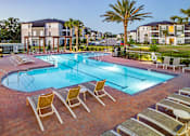Thumbnail 6 of 46 - A swimming pool surrounded by lounge chairs and palm trees.