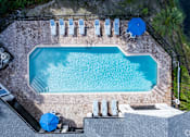 Thumbnail 14 of 48 - A rectangular pool surrounded by a brick patio and lounge chairs.