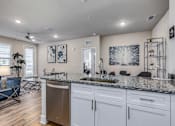 Thumbnail 12 of 46 - A kitchen with a granite countertop and white cabinets.
