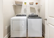 Thumbnail 8 of 46 - A small laundry room with a washer and dryer.