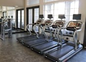 Thumbnail 4 of 44 - A gym with treadmills and elliptical machines.