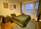 Thumbnail 10 of 25 - A bedroom with a bed, dresser, and window.