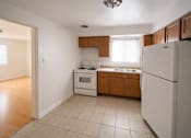 Thumbnail 5 of 5 - A kitchen with white appliances and wooden cabinets.