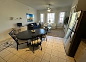 Thumbnail 7 of 29 - A black table with four chairs is in the middle of a kitchen and dining room.