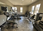 Thumbnail 17 of 29 - A gym with treadmills, elliptical machines, and other exercise equipment.