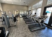 Thumbnail 20 of 29 - A gym with treadmills and elliptical machines.