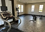 Thumbnail 18 of 29 - A treadmill with a monitor and control panel is in a spacious gym with other exercise equipment.