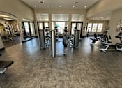 Thumbnail 21 of 29 - A gym with a variety of equipment including treadmills, weights, and exercise machines.
