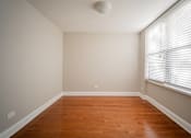 Thumbnail 79 of 86 - A room with wooden floors and a window with blinds.