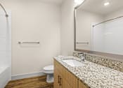 Thumbnail 19 of 50 - A bathroom with a toilet, sink, and mirror.