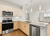 Thumbnail 9 of 50 - A kitchen with wooden cabinets and stainless steel appliances.