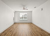 Thumbnail 13 of 50 - A room with a ceiling fan and wooden flooring.