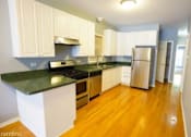 Thumbnail 2 of 14 - a kitchen with white cabinets and a stainless steel refrigerator