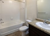 Thumbnail 12 of 21 - A white toilet sits next to a bathtub in a bathroom.
