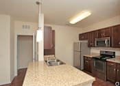 Thumbnail 8 of 21 - A kitchen with a granite counter top and stainless steel appliances.