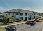 Thumbnail 4 of 21 - A black car with red stripes is parked in front of a building.