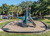 Thumbnail 19 of 21 - A playground with a blue slide and a brown sandbox.