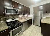 Thumbnail 5 of 15 - a kitchen with stainless steel appliances and granite countertops