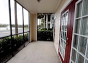 Thumbnail 5 of 44 - A balcony with a view of a body of water and trees.