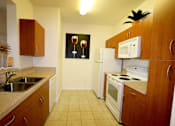 Thumbnail 15 of 44 - A kitchen with a fridge, microwave, and oven.