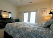 Thumbnail 29 of 44 - A bedroom with a bed, dresser, and mirror.