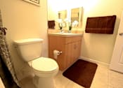 Thumbnail 6 of 44 - A white toilet sits in a bathroom next to a brown rug.