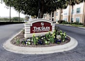 Thumbnail 8 of 44 - The sign for The Glen at Cagan Crossing is surrounded by flowers.
