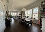 Thumbnail 2 of 8 - A dining room with a table and chairs.