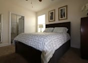 Thumbnail 40 of 44 - A bedroom with a bed, dresser, and mirror.