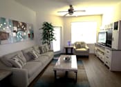 Thumbnail 41 of 44 - A living room with a grey couch and a coffee table.