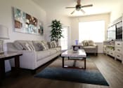 Thumbnail 31 of 44 - A living room with a couch, a coffee table, and a ceiling fan.