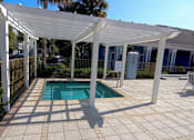 Thumbnail 23 of 44 - A pool under a white pergola on a sunny day.