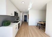 Thumbnail 18 of 84 - A kitchen with white cabinets and a wooden floor.