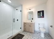 Thumbnail 26 of 84 - A white toilet sits next to a sink in a bathroom.