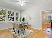 Thumbnail 14 of 27 - A dining room with a table and chairs.