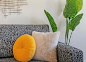 Thumbnail 5 of 27 - A grey couch with a yellow pillow and a white pillow on it.