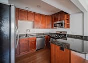 Thumbnail 65 of 86 - A kitchen with wooden cabinets and a black refrigerator.