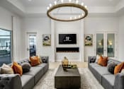 Thumbnail 18 of 46 - A modern living room with grey couches and a chandelier.