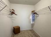 Thumbnail 48 of 48 - A small closet with a white wall and a carpeted floor.