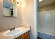Thumbnail 12 of 24 - A bathroom with a sink and a bathtub.