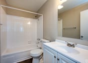 Thumbnail 11 of 24 - A white bathroom with a toilet, sink, and bathtub.