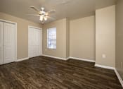 Thumbnail 13 of 24 - A room with wooden flooring and a ceiling fan.