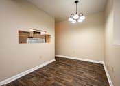 Thumbnail 17 of 24 - A room with wooden flooring and a chandelier hanging from the ceiling.