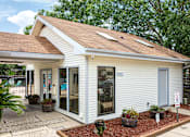 Thumbnail 2 of 24 - A small white building with a brown roof and a sign that says "EXIT".