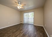 Thumbnail 19 of 24 - A room with a ceiling fan and sliding glass doors.